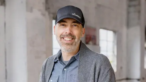 Atomo Andy Kleitsch, the chief executive of Seattle based start-up Atomo, smiling and wearing a baseball cap