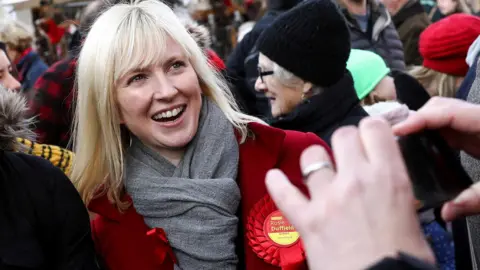 Reuters Rosie Duffield attends a Labour rally wearing a red rosette in 2019