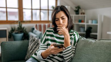 Person sitting on a couch, looking at their phone.