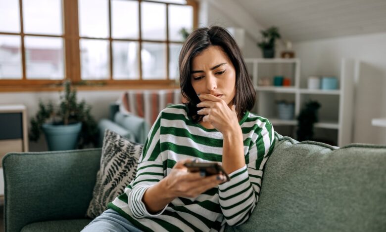 Person sitting on a couch, looking at their phone.