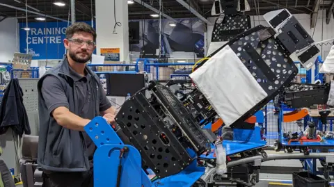 Chris Baraniuk Eoin Murray, operations manager at Thompson Aero Seating, stands next to a jig holding a partly assembled airline seat