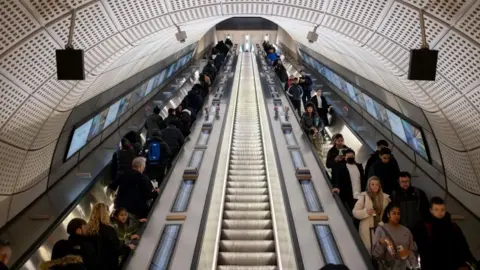 Getty Images Commuters on escalators at Elizabeth line station