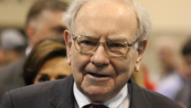 Warren Buffett surrounded by people at Berkshire Hathaway's annual shareholder meeting.