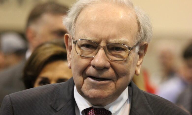 Warren Buffett surrounded by people at Berkshire Hathaway's annual shareholder meeting.