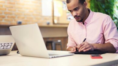 An investor studies something on a laptop at home.