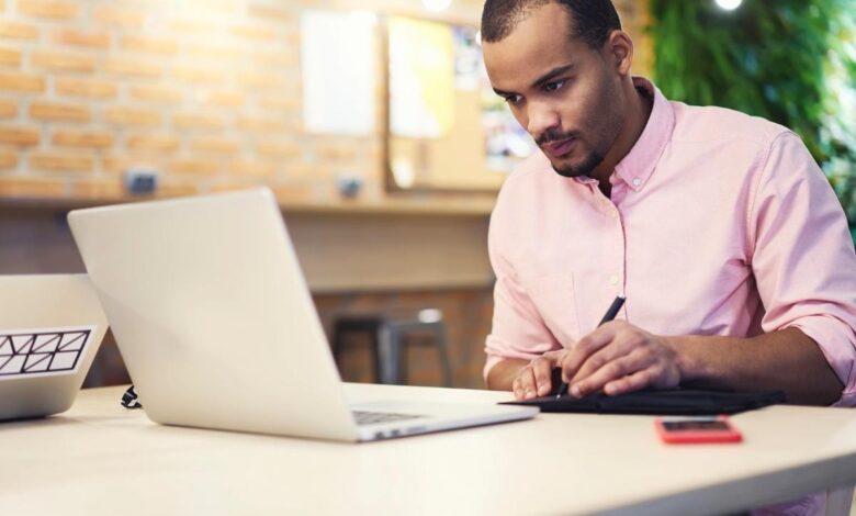 An investor studies something on a laptop at home.