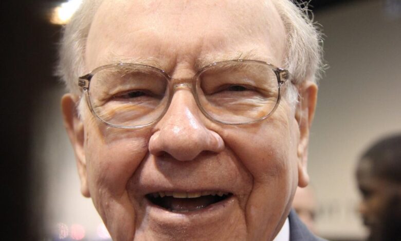 A jubilant Warren Buffett surrounded by people at Berkshire Hathaway's annual shareholder meeting.