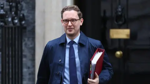 Getty Images Chief Secretary to the Treasury Darren Jones walking out of Downing Street carrying a red folder