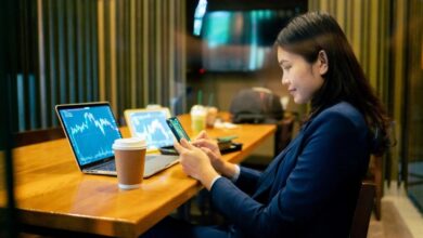 A person siting at a desk looking at graphs on multiple device monitors.