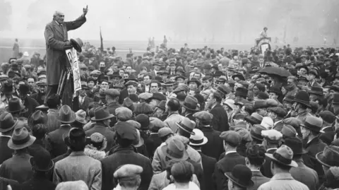 Getty Images 24th September 1933: Addressing crowds at Speakers' Corner in Hyde Park, Communist MP Saklatvala Shapurji calls for the release of the Reichstag Fire suspects in Germany. The fire, which burned down the Reichstag parliament building, was allegedly started by Communist Party member Marinus van der Lubbe and gave the German government a pretext to introduce a state of emergency across the country and suppress opponents of the Nazi regime. (Photo by Keystone/Getty Images)