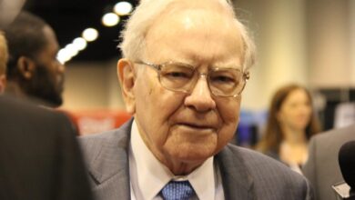 Warren Buffett surrounded by people at Berkshire Hathaway's annual shareholder meeting.