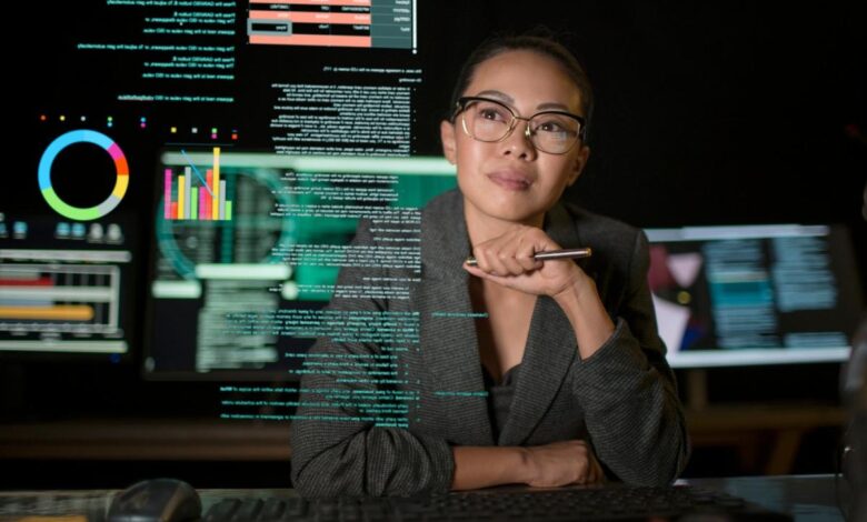 A person studying a see-through display of various charts and graphs.