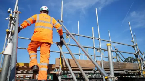 Getty Images HS2 construction worker wearing hi-vis clothing climbing scaffolding