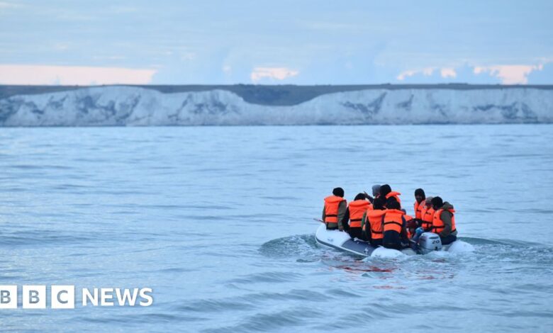 Migrants in a dinghy sail in the Channel toward the south coast of England