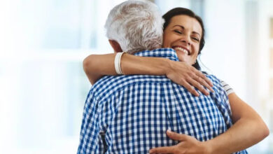 A woman hugs her father after receiving a $50,000 gift to be put toward her down payment on a home.