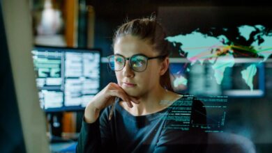 A person staring at graphs and charts on a computer monitor.