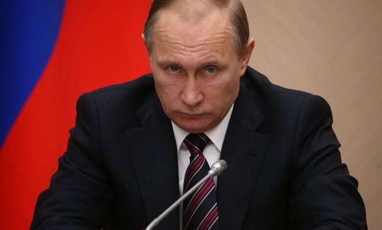 Vladimir Putin looking into the camera with a straight face.