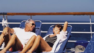 A couple sitting on the deck of a cruise ship.