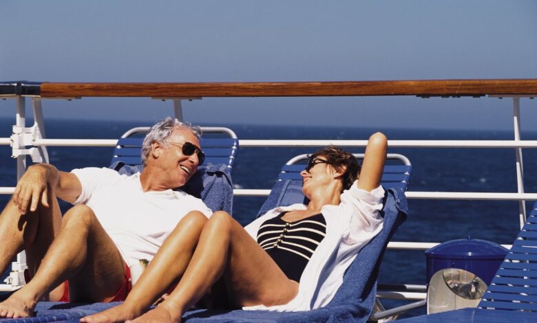 A couple sitting on the deck of a cruise ship.