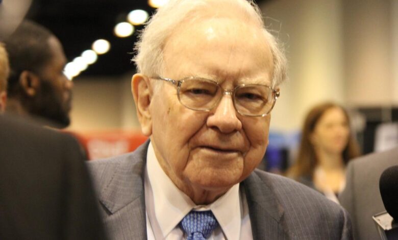 Warren Buffett surrounded by people at Berkshire Hathaway's annual shareholder meeting.