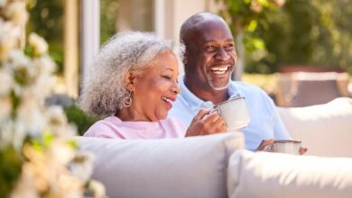 A retired couple sitting on their patio drinking coffee.