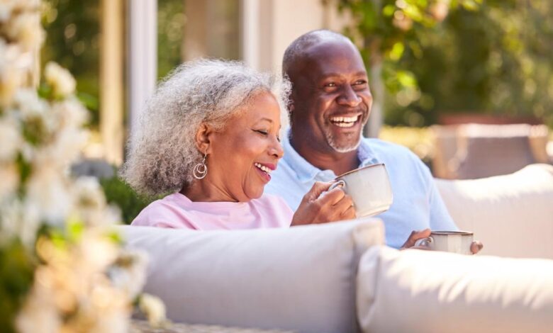 A retired couple sitting on their patio drinking coffee.