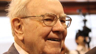 A jovial Warren Buffett surrounded by people at Berkshire Hathaway's annual shareholder meeting.