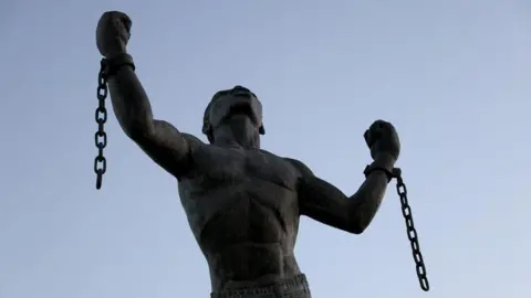 Getty Images A statue of an enslaved person breaking their shackles.