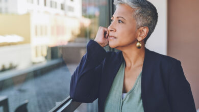 A woman looks out of the window in her office and contemplates whether she can afford to retire at 66.