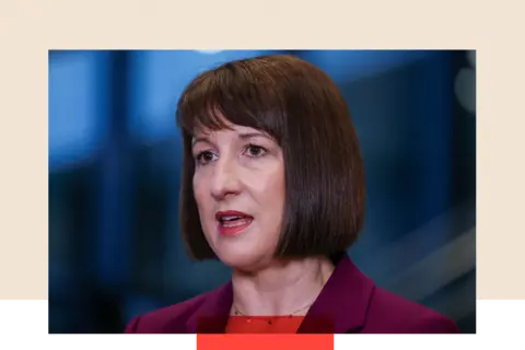 Getty Images A close-up of Rachel Reeves during an interview at the UK Labour Party annual conference, captured mid-sentence with her mouth slightly open. She is wearing a gold necklace and a burgundy blazer, with her short bob and fringe hairstyle.