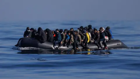 Getty Images A black inflatable dinghy full of people crosses the English Channel in March 2024