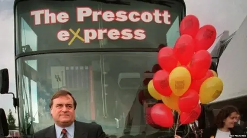 Rex Features John Prescott stands in front of a bus with a sign saying The Prescott Express 