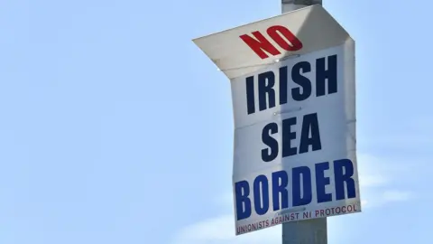 Reuters A sign on a lamppost in red white and blue lettering says No Irish Sea Border with unionists against NI Protocol on smaller writing at the bottom