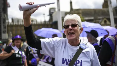 Getty Images Waspi campaigners outside Parliament wearing badges and t-shirts about their campaign.