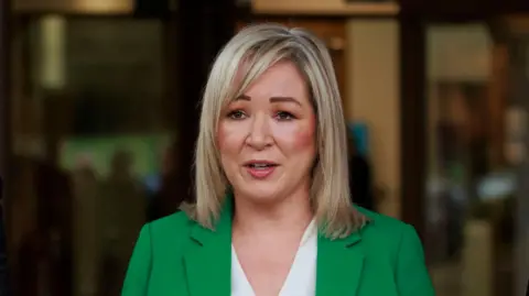 PA Media Michelle O'Neill. She has shoulder length blonde hair, wearing a green blazer and white top.