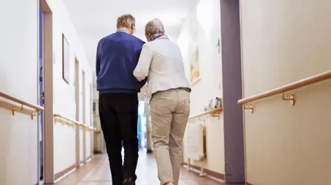 Getty Images two people walking down a corridor 