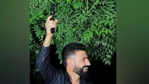 NCA Amanj Hasan Zada, a jailed people smuggler, firing a gun in celebration at a party. 