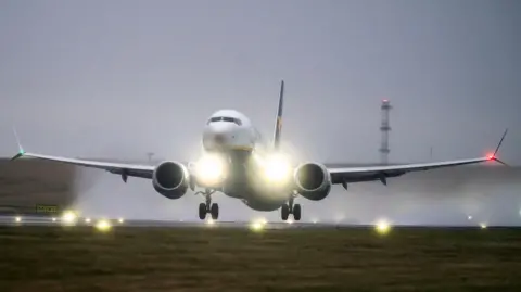 PA Media Image shows a plane landing at an airport. 
