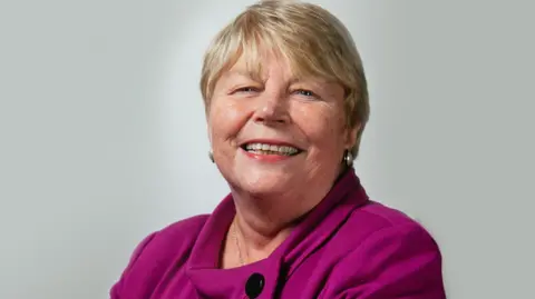 Welsh Liberal Democrats Baroness Jenny Randerson smiles at the camera. She is wearing a purple top.