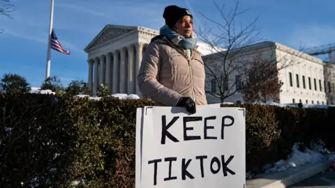 Getty Images A woman holding a sign reading 'Keep TikTok' standing in cold-weather clothes outside the Supreme Court in the US.