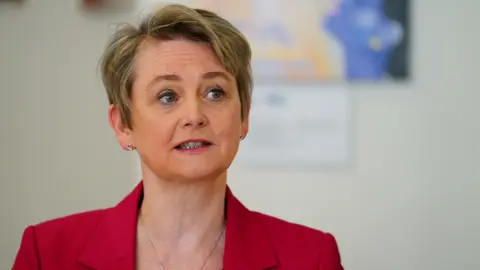 PA Media Home Secretary Yvette Cooper wearing a red suit