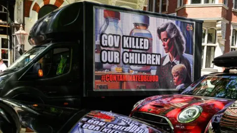 Getty Images A van parked outside the infected blood inquiry in May 2020. On the side is an advertising hoarding saying 