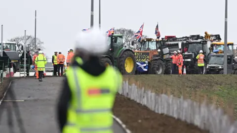 Reuters A protest takes place as British Prime Minister Keir Starmer visits a housing construction site