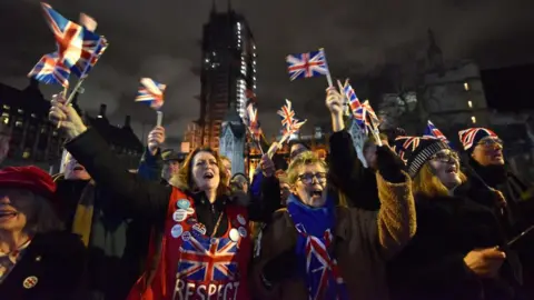 Getty Images Brexit supporters waving Union Jacks outside Parliament celebrate the UK leaving the EU on 31 January 2020. 