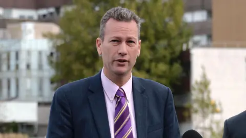 Getty Images Nathan Gill stood wearing a tie in UKIP colours in-front of a microphone