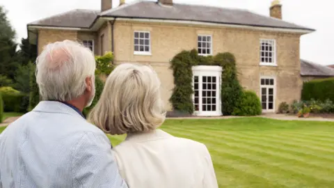 Getty Images An older couple looking at a large country house