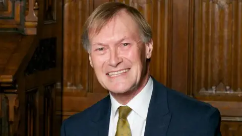 Getty Images Sir David Amess smiling at the camera while wearing a suit 