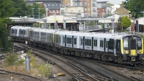 PA Media A blue and white South Western Railway train leaves Basingstoke station.