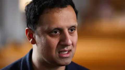 Getty Images Anas Sarwar has dark hair and is wearing a dark t-shirt