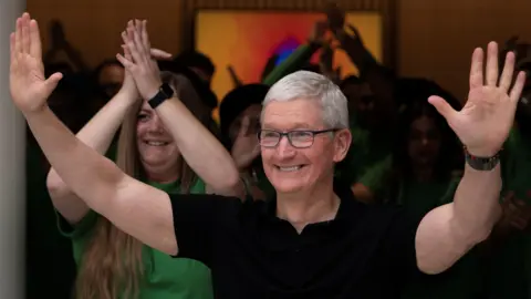Reuters Apple CEO Tim Cook in a black t-shirt gestures with both hands during the inauguration of an Apple retail store in New Delhi, India, April 20, 2023